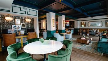 a dining room with green chairs and a white table at Kendall Park Too, Columbus